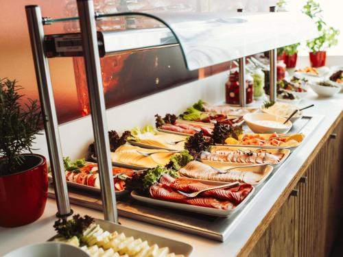 a buffet line with many different types of food at Ibis Poznan Polnoc in Suchy Las