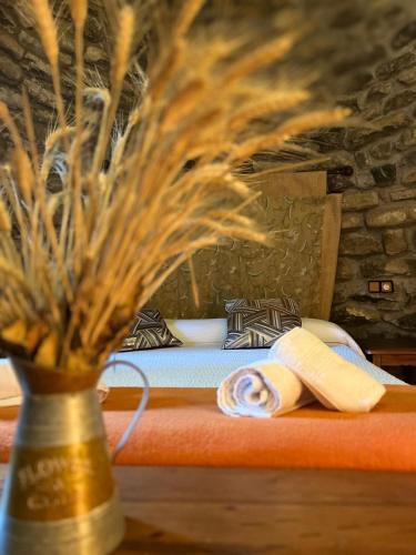 a bedroom with a bed and a vase with flowers at Fonda Carrera in Labuerda