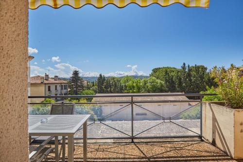 a balcony with a table and a view at Appart Hotel Odalys City Aix en Provence Les Floridianes in Aix-en-Provence