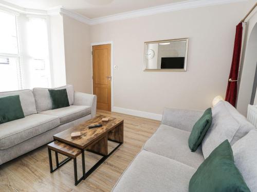 a living room with a couch and a coffee table at Llandudno Central - 5 Bedroom House in Llandudno