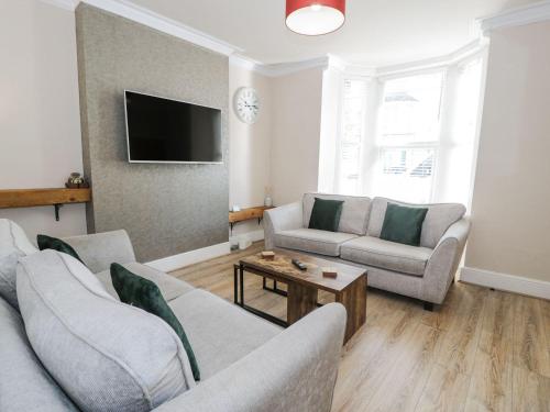 a living room with two couches and a tv at Llandudno Central - 5 Bedroom House in Llandudno