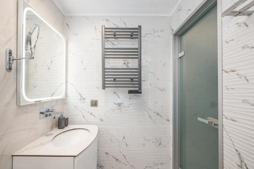 a white bathroom with a sink and a shower at Diamante Del Mar Crete Rhodes in Kos