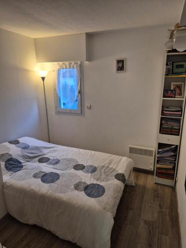 une petite chambre avec un lit et une fenêtre dans l'établissement Proche plage, à Saint-Raphaël