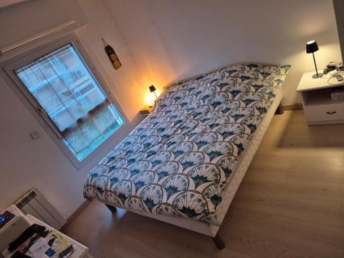 un grand lit dans une chambre avec une fenêtre dans l'établissement Proche plage, à Saint-Raphaël