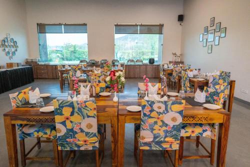 a dining room with wooden tables and chairs with flowers on them at Bamboo Saa Mulberry Resort Pushkar in Pushkar
