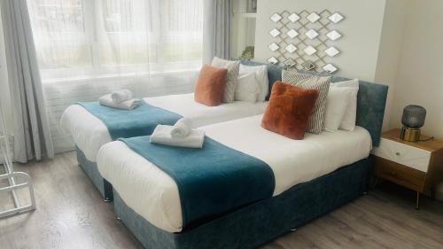two beds with towels on them in a bedroom at Business Leisure Near Canary Wharf Free Parking in London