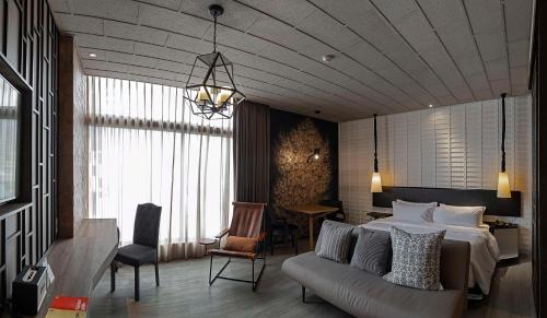a bedroom with a bed and a couch and a table at Siam@Siam, Design Hotel Bangkok in Bangkok