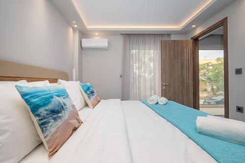 a bedroom with a large bed with blue and white pillows at Diamante Del Mar Crete Rhodes in Kos