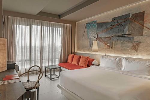 a bedroom with a large white bed and a couch at Siam@Siam, Design Hotel Bangkok in Bangkok