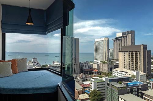 a bedroom with a view of a city at Siam@Siam Design Hotel Pattaya in Pattaya Central