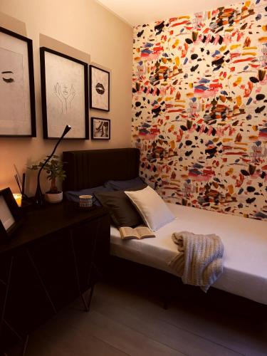 a bedroom with a bed with a colorful wall at Suite privata con terrazza in Bologna