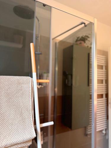 a glass shower door with a chair in a bathroom at Suite privata con terrazza in Bologna