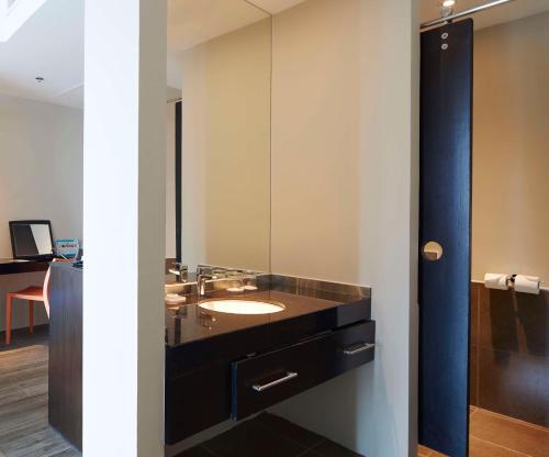 a bathroom with a sink and a mirror at Siam@Siam Design Hotel Pattaya in Pattaya Central