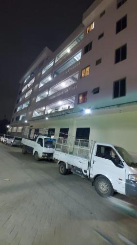 three white trucks parked in front of a building at PureBliss Homes in Mombasa