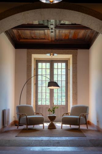 a room with two chairs and a large window at MS Collection Arouca - Mosteiro de Arouca in Arouca