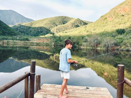 a boy standing on a dock fishing on a lake at Pat Busch Mountain Reserve in Robertson