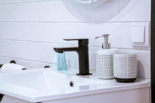 a bathroom sink with a faucet and a soap dispenser at Mar-Ria 6 in Fuzeta