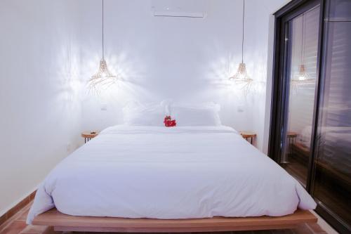 a white bed in a room with two lights at Mar-Ria 6 in Fuzeta
