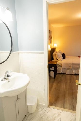 a bathroom with a sink and a bedroom with a bed at Tranquil Retreats on Robinson in Moncton