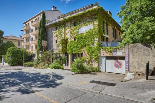 a building covered in ivy on the side of a street at Appart Hotel Odalys City Aix en Provence Les Floridianes in Aix-en-Provence