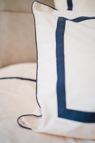 a blue and white pillow on a bed at Château de la Bousquetarie in Lempaut