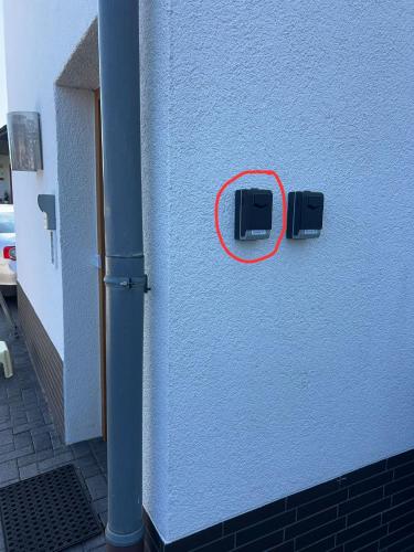 a red button on the side of a building at Zimmer 1 inkl eigenem Bad und Parkplatz in Waldböckelheim