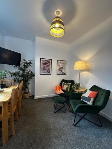 ウィガンにあるWigan 1BR Haven - Perfect for a Relaxing Stayのテーブルと椅子のあるリビングルームとダイニングルーム
