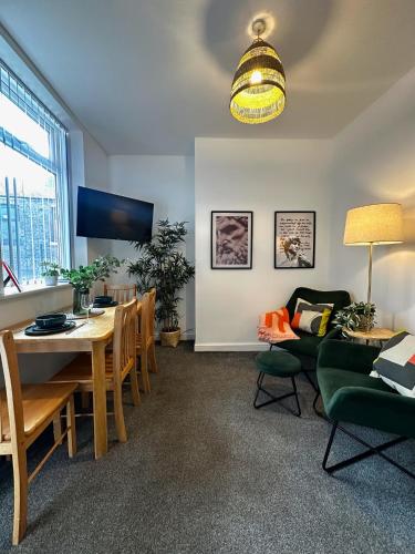 ウィガンにあるWigan 1BR Haven - Perfect for a Relaxing Stayのテーブルとダイニングルームのあるリビングルーム