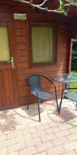 two chairs and a table in front of a building at Napfény Camping in Taliándörögd