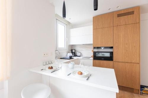 une cuisine avec des comptoirs blancs et un comptoir blanc dans l'établissement GuestReady - Elegant Escape near Plaza Athénée, à Paris