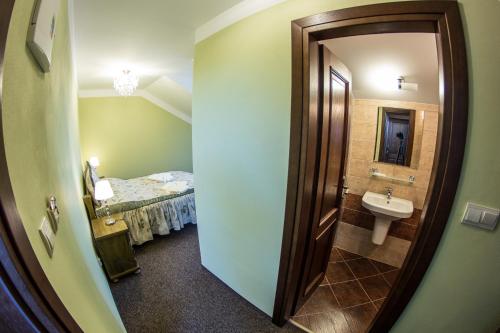 a bathroom with a bed and a sink and a mirror at Penzión Altmayer in Banská Štiavnica