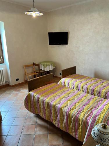 a bedroom with two beds and a table and a tv at La Fonte B&B in Baranello