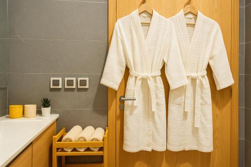 a robe hanging on a door in a bathroom at BlueVista - Yacht like Escape with Ocean Views in Rabat