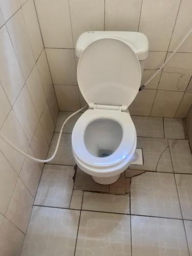 a bathroom with a toilet with a hose at Travel for Charity Tanzania- Eco Hostel & Volunteer Center in Arusha
