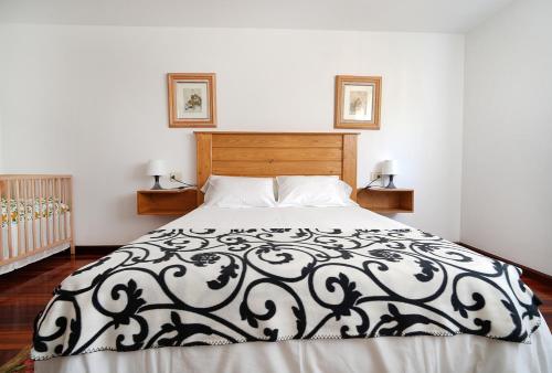 Un dormitorio con una cama con un edredón blanco y negro. en Casa con jardín en Vilanova de Arousa, en Villanueva de Arosa
