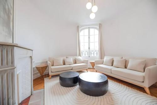- un salon avec deux canapés blancs et une table dans l'établissement TBS 327 - Superb apartment with Eiffel Tower view, à Paris