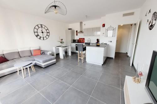 un salon avec un canapé et une cuisine dans l'établissement Nice and peaceful 55m close to the city centre, à Aix-en-Provence