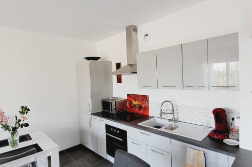 une cuisine blanche avec des armoires blanches et un évier dans l'établissement Nice and peaceful 55m close to the city centre, à Aix-en-Provence