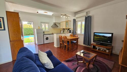 a living room with a blue couch and a table at Casinha; Piscina/ Praia/ Lisboa in Aroeira