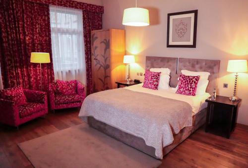 a bedroom with a large bed and two chairs at Tigerlily in Edinburgh