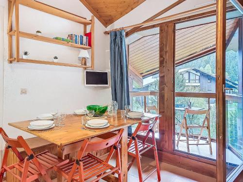 une salle à manger avec une table et des chaises et une fenêtre dans l'établissement Apartment Pierres Blanches F et H-10 by Interhome, à Le Cugnon