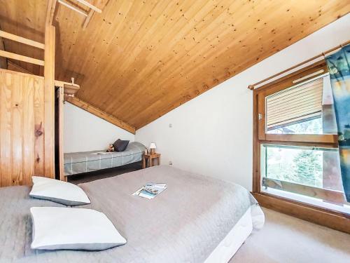 une chambre avec un lit et un plafond en bois dans l'établissement Apartment Pierres Blanches F et H-10 by Interhome, à Le Cugnon