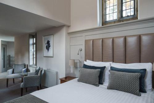 a bedroom with a large bed with blue pillows at Fanhams Hall, Exclusive Collection in Ware