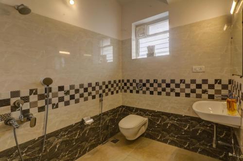 a bathroom with a toilet and a sink at Ludo Private Pool Villa, WiFi-Caretaker-Parking, North Goa in Baga