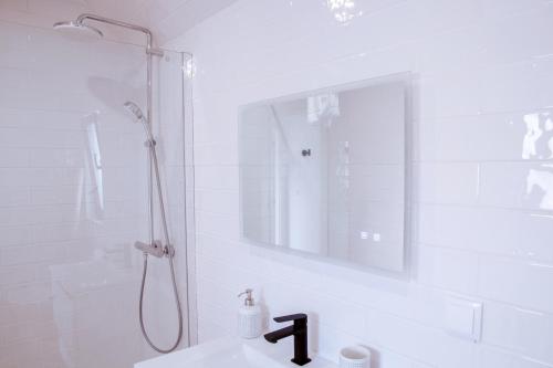 a white bathroom with a shower and a sink at Mar-Ria 7 in Fuzeta