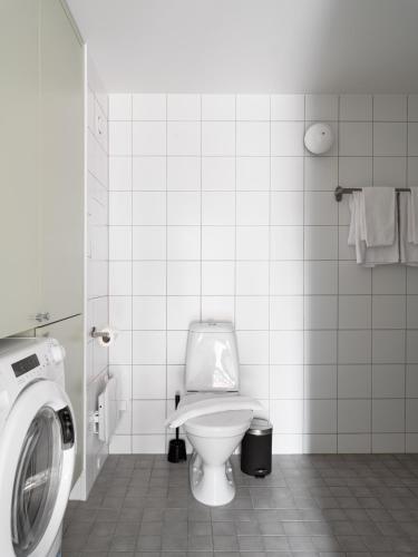 a bathroom with a toilet and a washing machine at Waterfront Cabins in Gothenburg