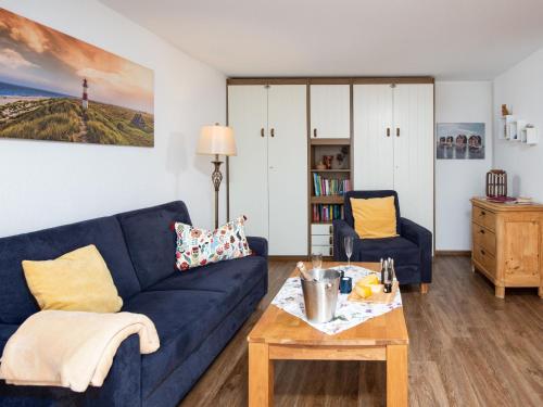 ein Wohnzimmer mit einem blauen Sofa und einem Tisch in der Unterkunft Apartment Ballertutje by Interhome in Norddeich