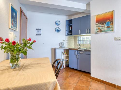 une cuisine avec une table avec un vase de fleurs dans l'établissement Apartment Lovrano-1 by Interhome, à Lovran