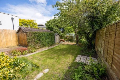 a backyard with a fence and a grass yard at Primrose - Refurbished Family Home, With Rear Garden in Poole