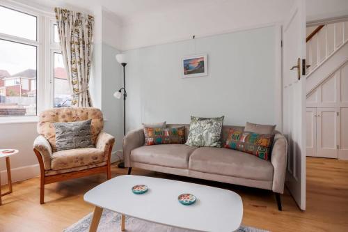 a living room with a couch and a chair at Primrose - Refurbished Family Home, With Rear Garden in Poole
